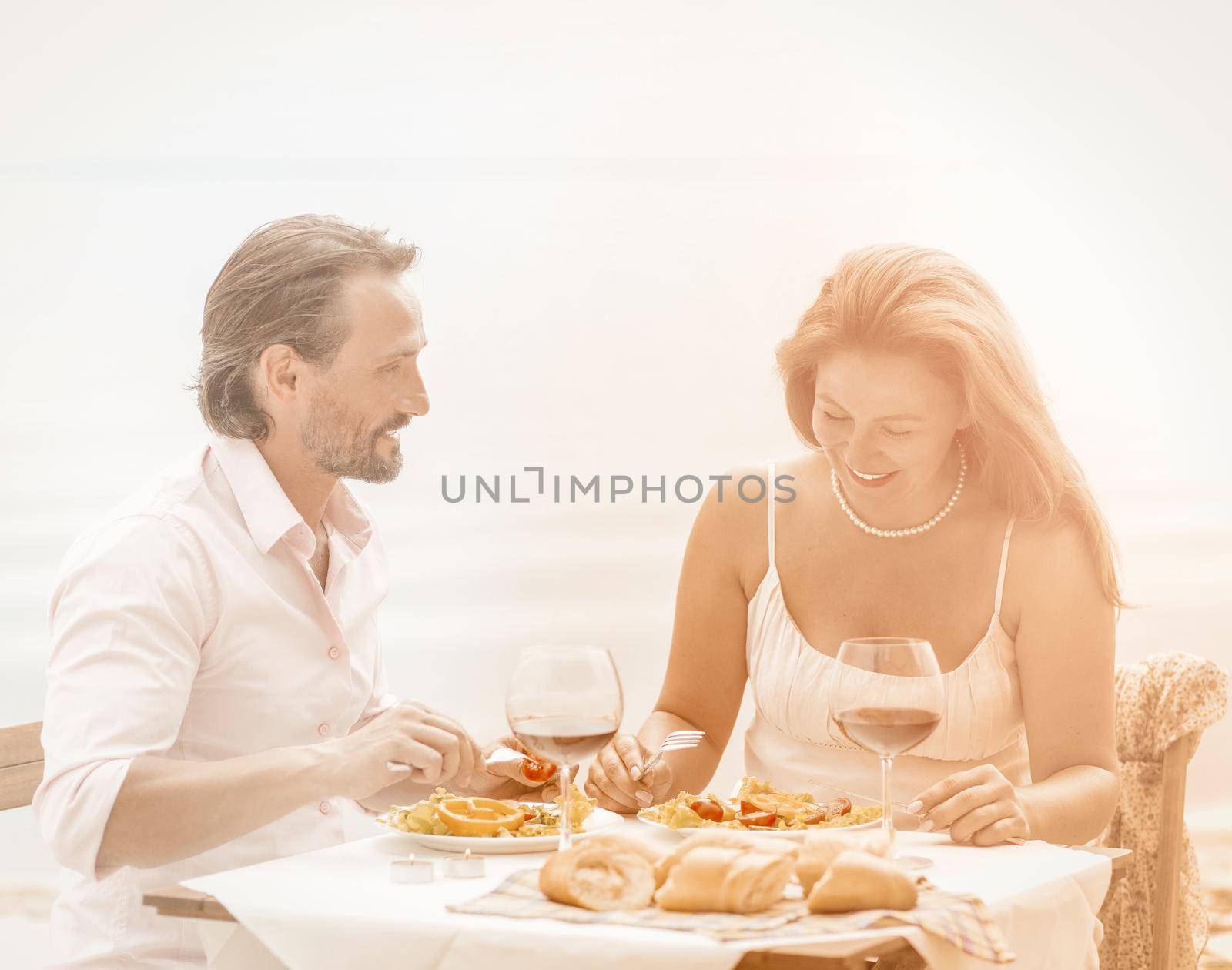 Couple dating dinner. Happy lovers on table in restaurant.