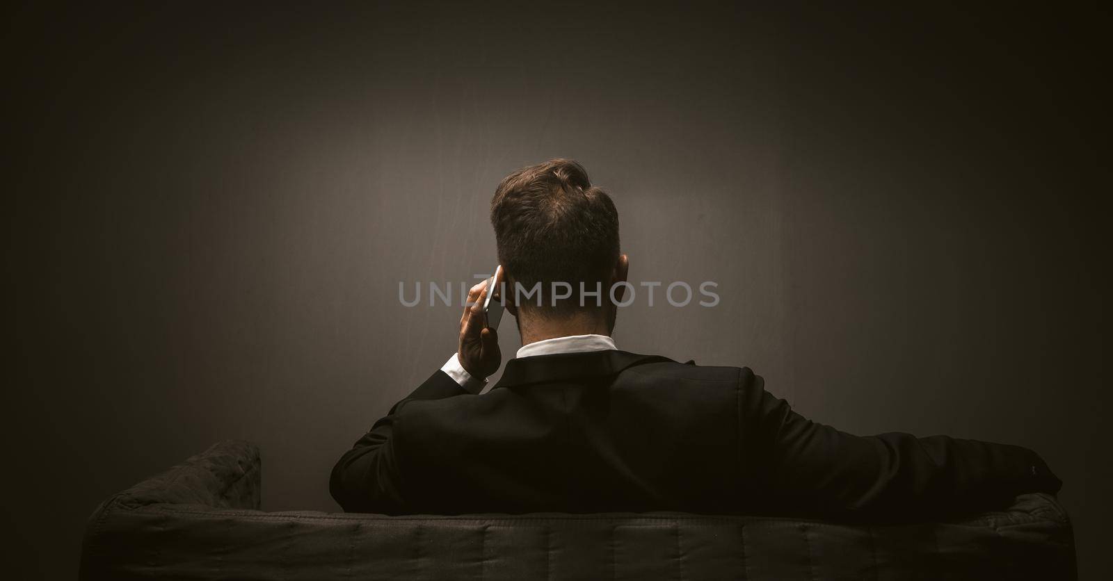 Modern business person on dark backdrop. Mobile phone wireless communication concept. Mobile communications.