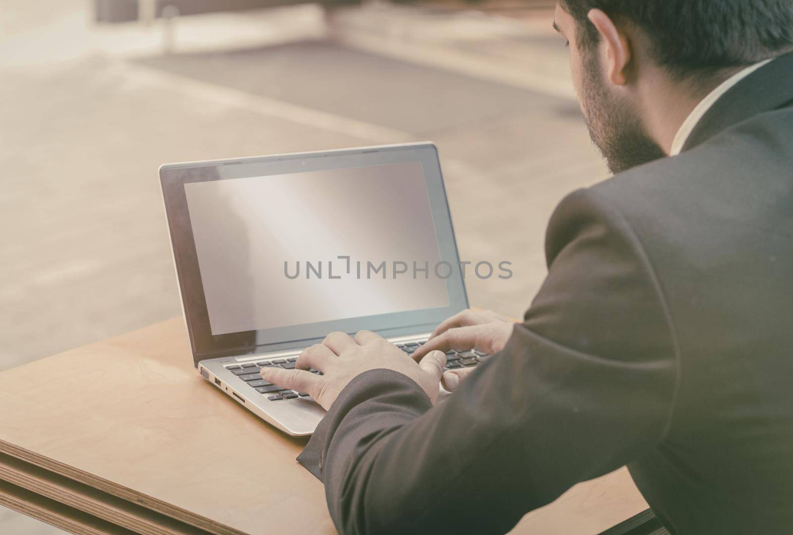 Back view businessman work for lifestyle design. Creative concept. Business career concept. Wooden table background by LipikStockMedia