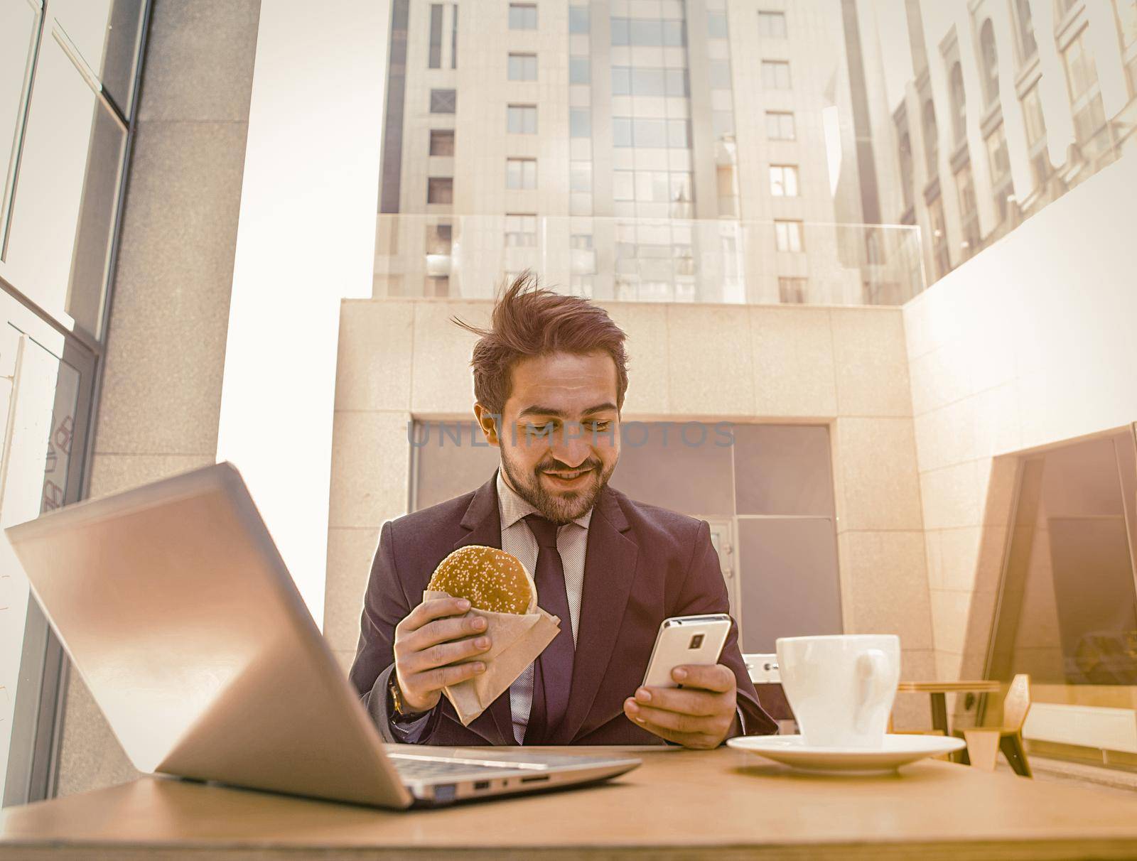 Businessman working in cafe on break. by LipikStockMedia