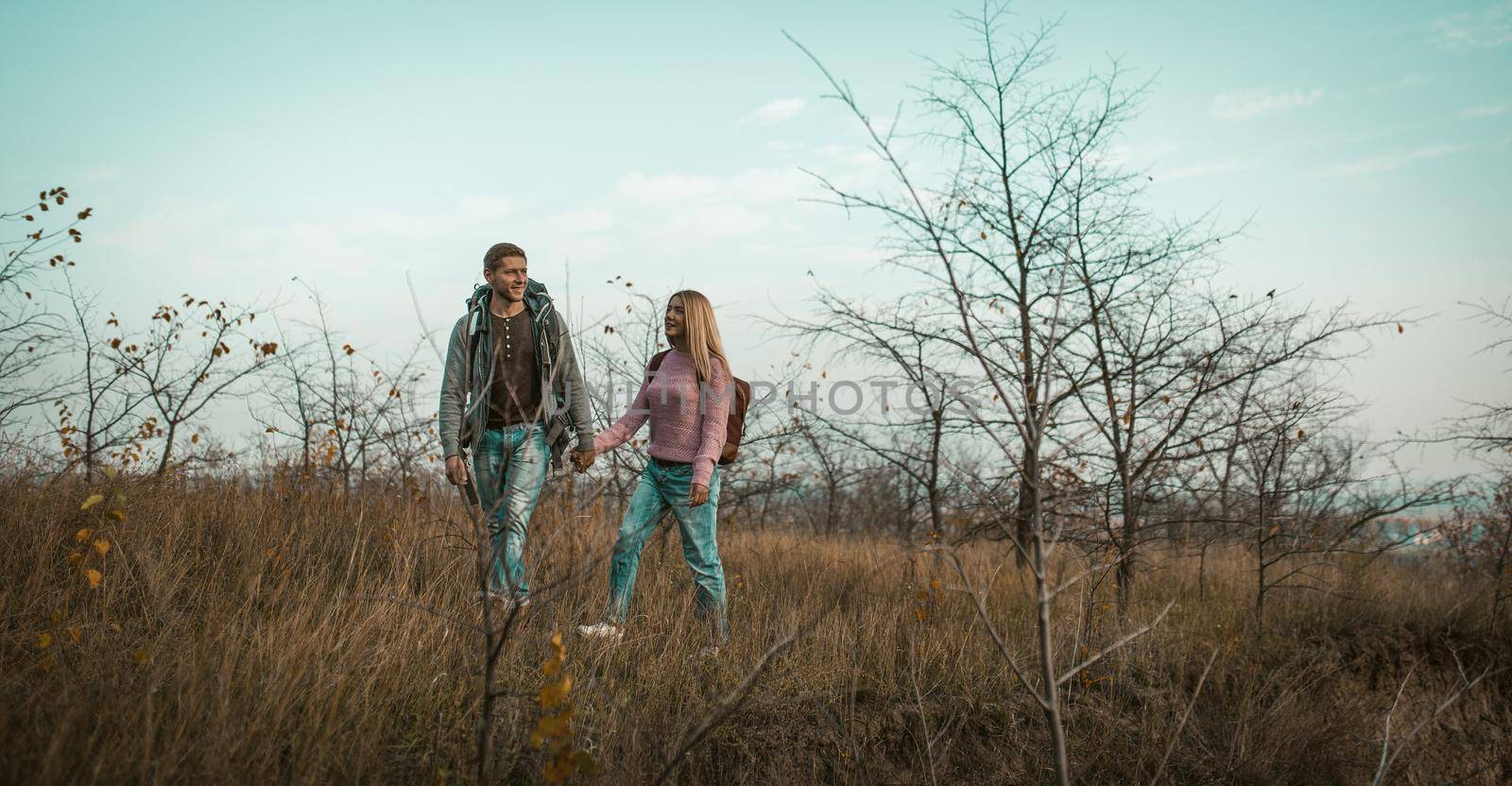 Cheerful Man And Woman Walk Outdors Holding Hands by LipikStockMedia