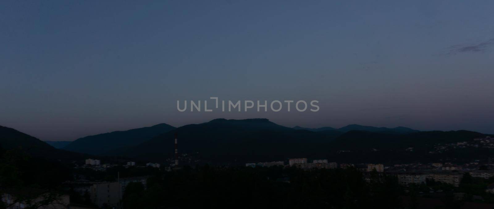 LAZAREVSKOE, SOCHI, RUSSIA - MAY, 27, 2021: Panorama of sunset in the mountains. A magical view of the sea and small town from the observation deck.