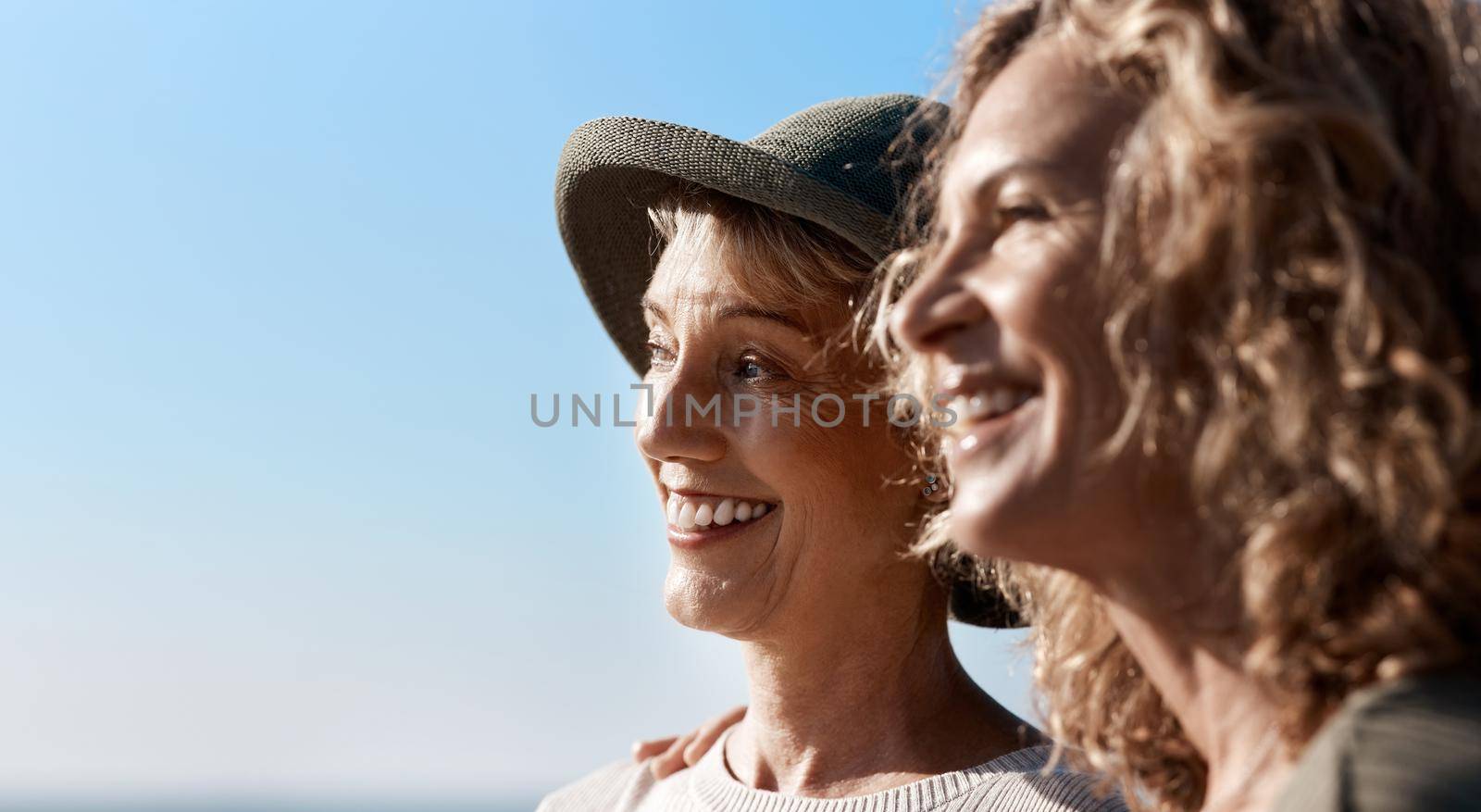 Taking in the views. two attractive mature women standing on the beach