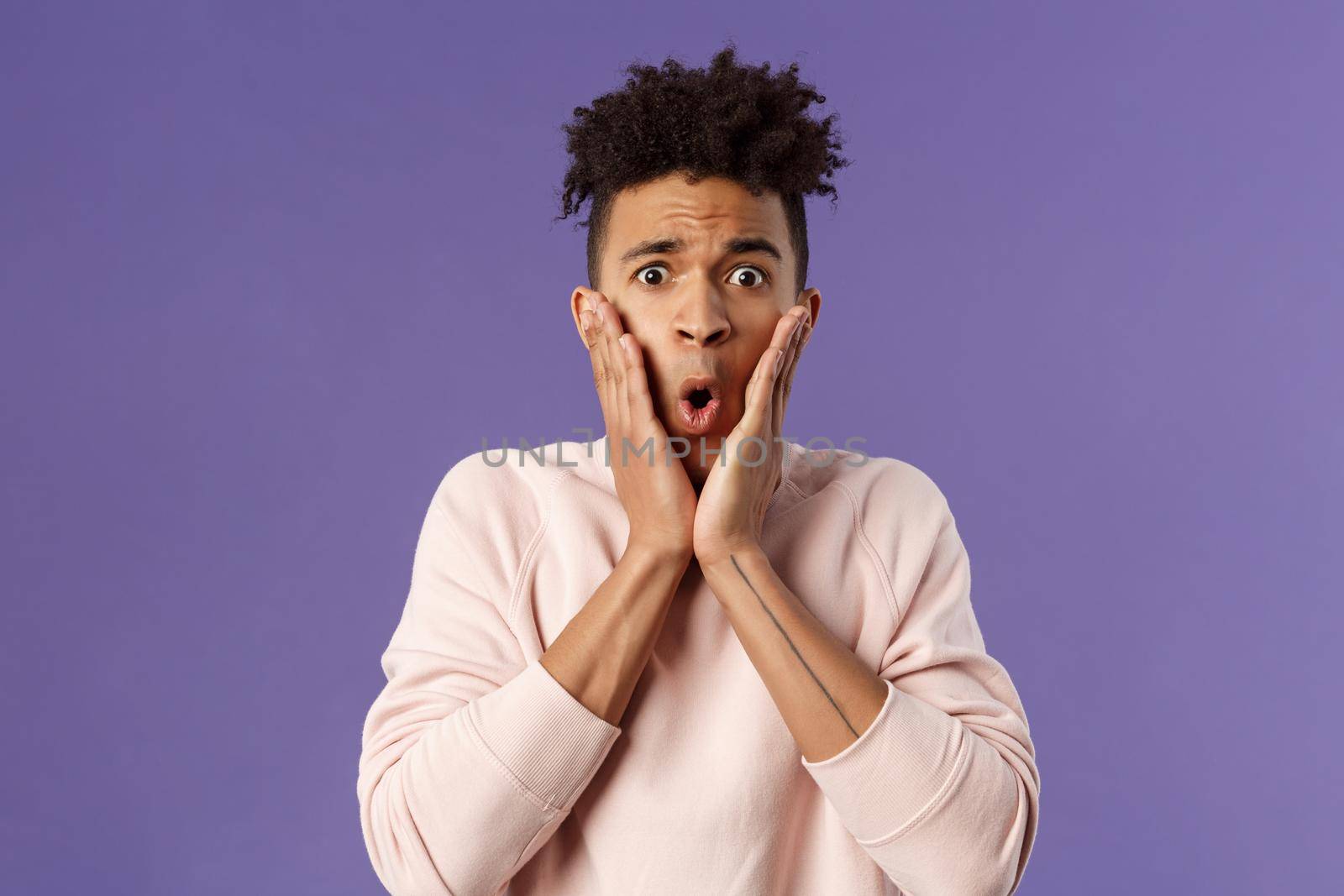 Close-up portrait of concerned, embarrassed young man hold hands on cheeks looking desperate and alarmed, feel worried about first date, being indecisive dont know what do by Benzoix