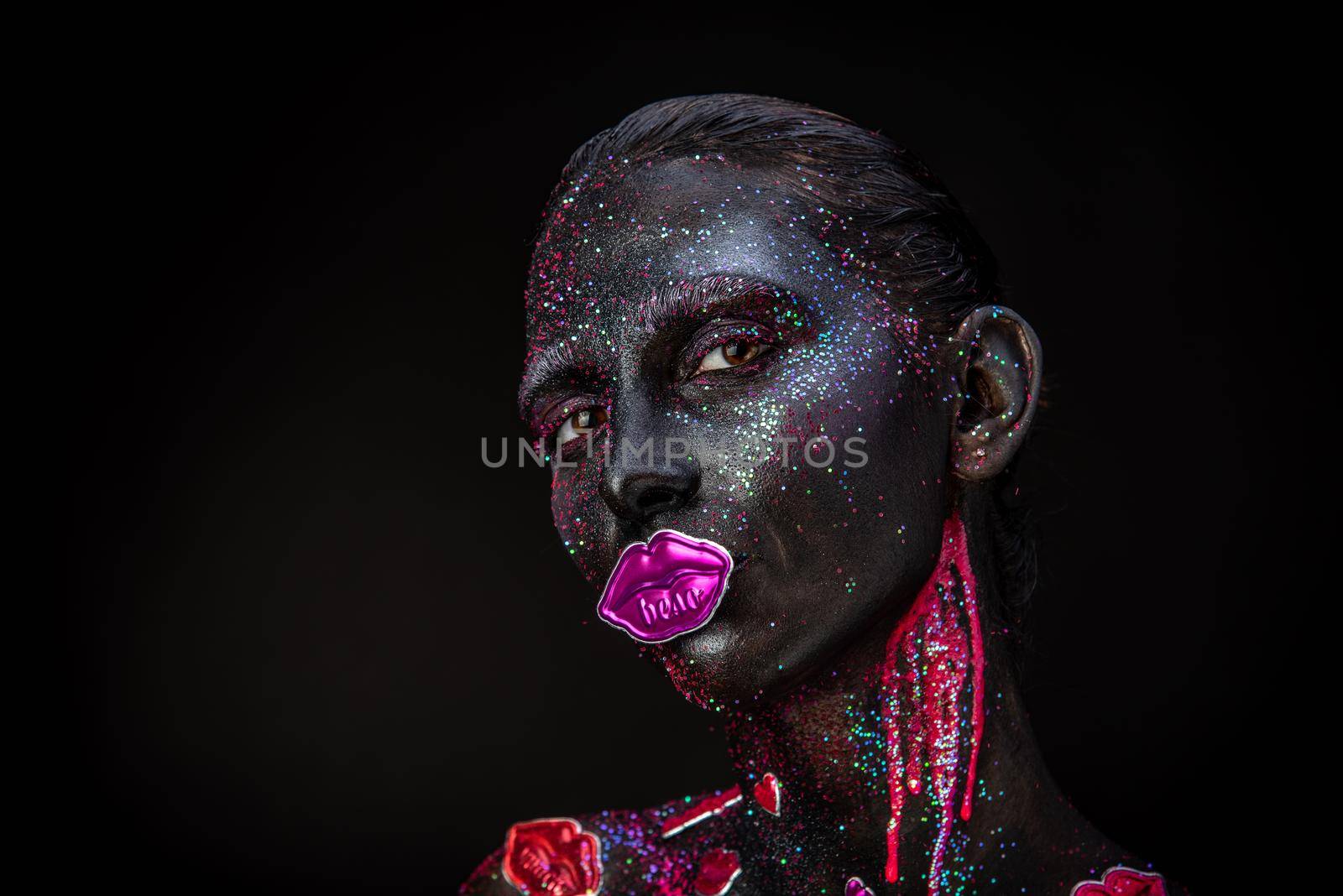 Mystical woman makeup with sparkles and luminous elements on a dark background