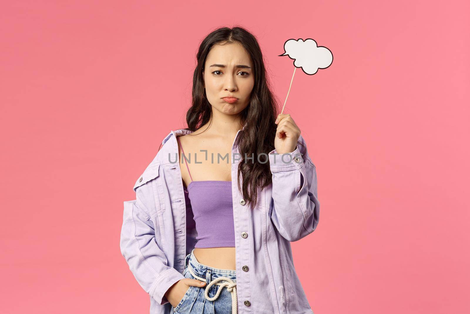 Holidays, lifestyle and people concept. Portrait of gloomy, sulking asian girl dont have any ideas, holding thinking cloud stick and look upset camera as cant figure out plan, pink background by Benzoix