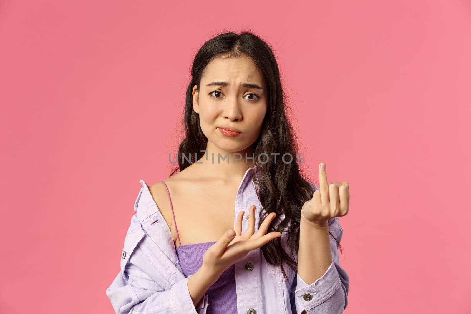Women, relationship and people concept. Close-up portrait of gloomy complaining asian girl showing finger without ring, smirk and frowning upset, want get married, why boyfriend dont make proposal by Benzoix