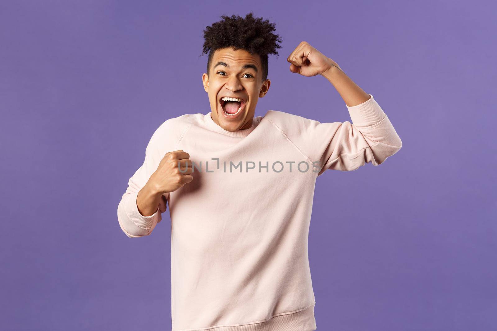 Portrait of excited happy man seeing his team scored goal on sports tv channel, chanting raise one hand in triumph, screaming in joy and happiness, celebrating victory, placed right bet.