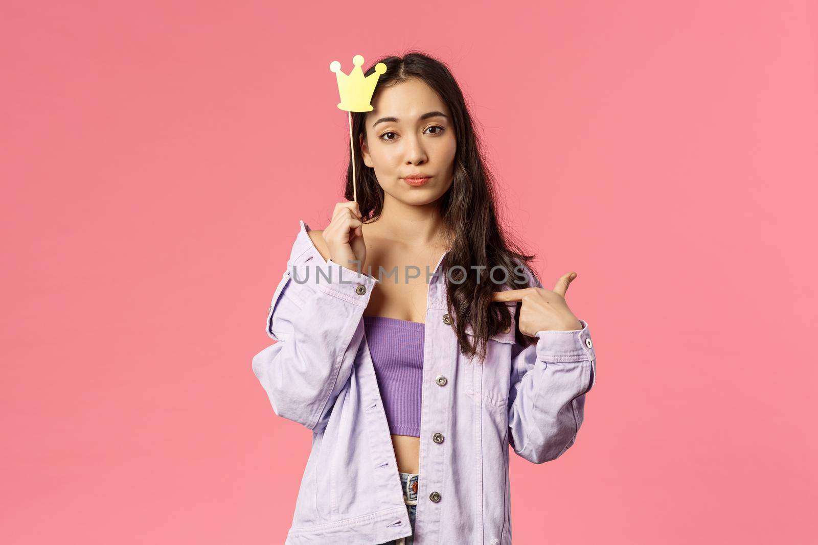 Holidays, lifestyle and people concept. Portrait of confident, sassy young asian woman pointing herself, feeling assertive being a top, hold queen crown stick, pink background by Benzoix