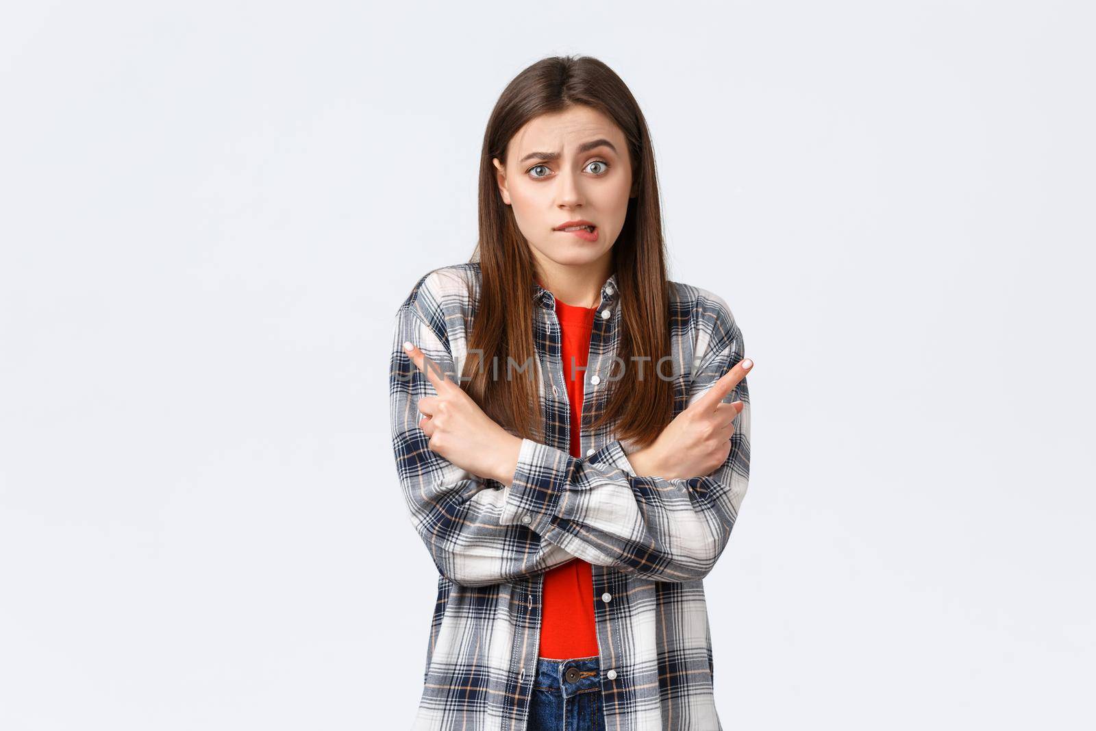 Lifestyle, different emotions, leisure activities concept. Indecisive puzzled cute girl biting lip and pointing sideways left and right choices, facing difficult decision, asking for advice by Benzoix