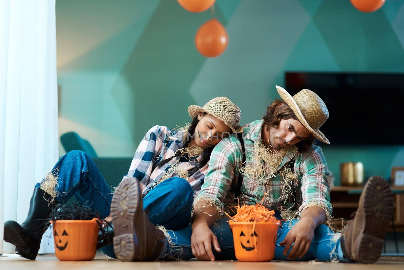 Halloween really wore us out this year. a young couple in halloween costumes sleeping at home