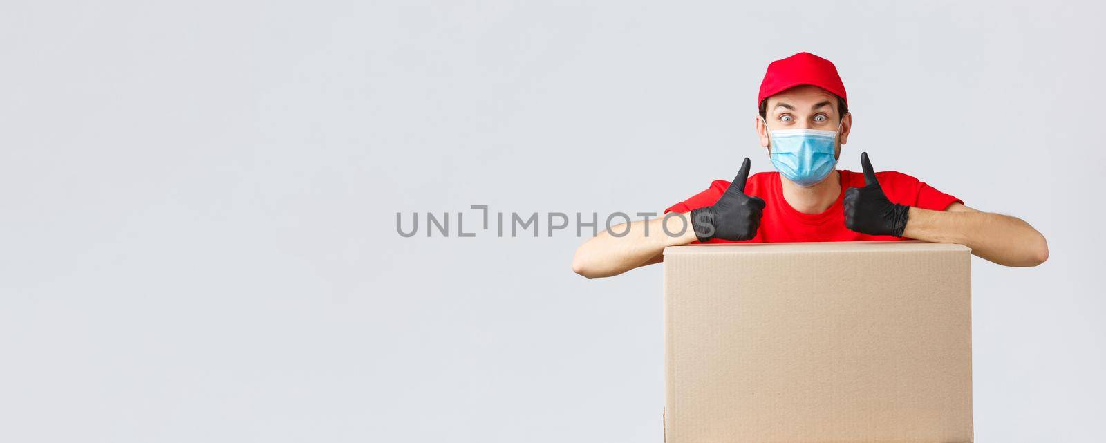 Packages and parcels delivery, covid-19 quarantine and transfer orders. Enthusiastic courier in red uniform, face mask and gloves, lean on box order and thumb-up, recommend service, express shipping by Benzoix