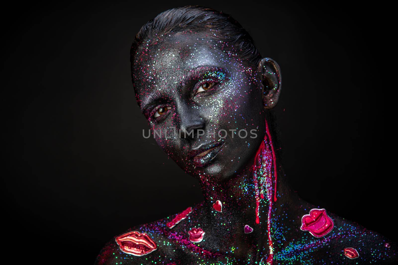 Mystical woman makeup with sparkles and luminous elements on a dark background