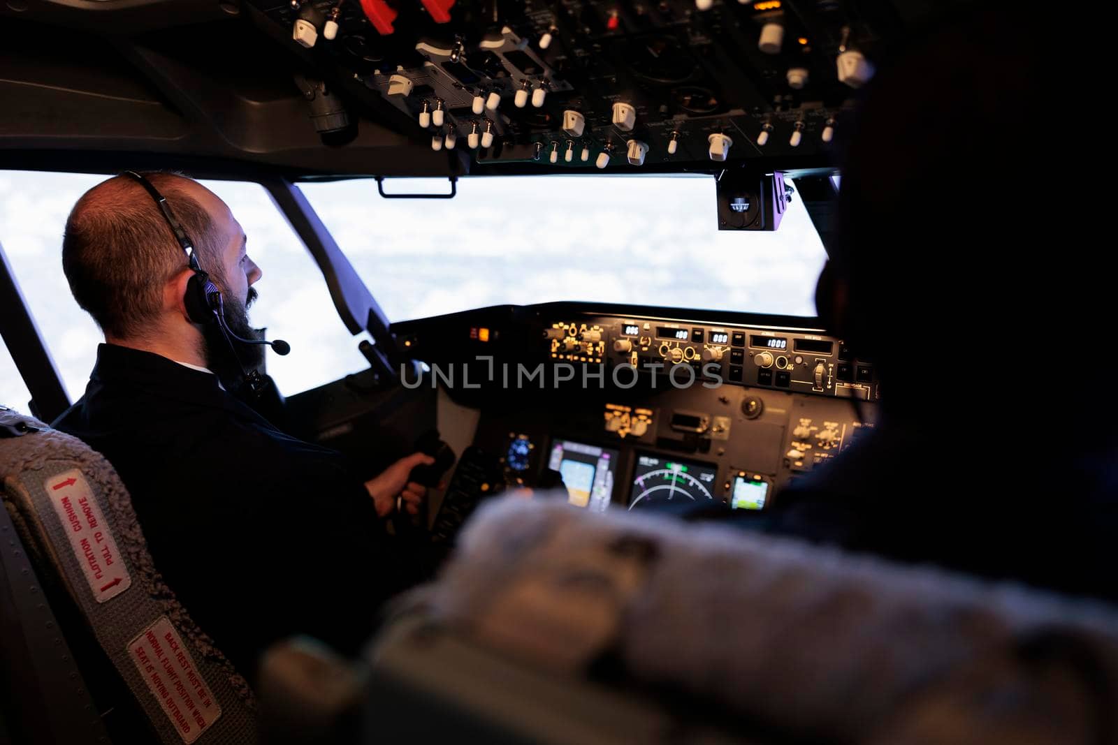 Male aviators flying airplane from cockpit with control panel and dashboard command, pushing power buttons to travel. Aircrew members using radar switch and navigation compass to fly.