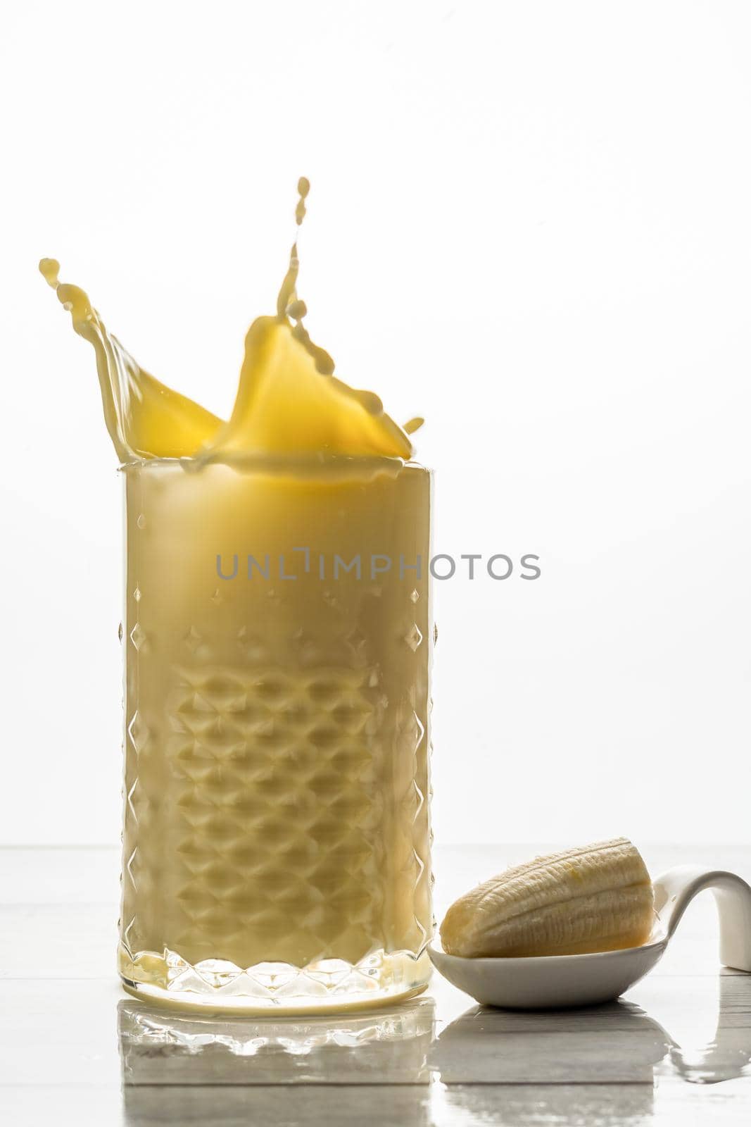 banana smoothie with fresh fruit and cookie splash effect, white background and copy-space