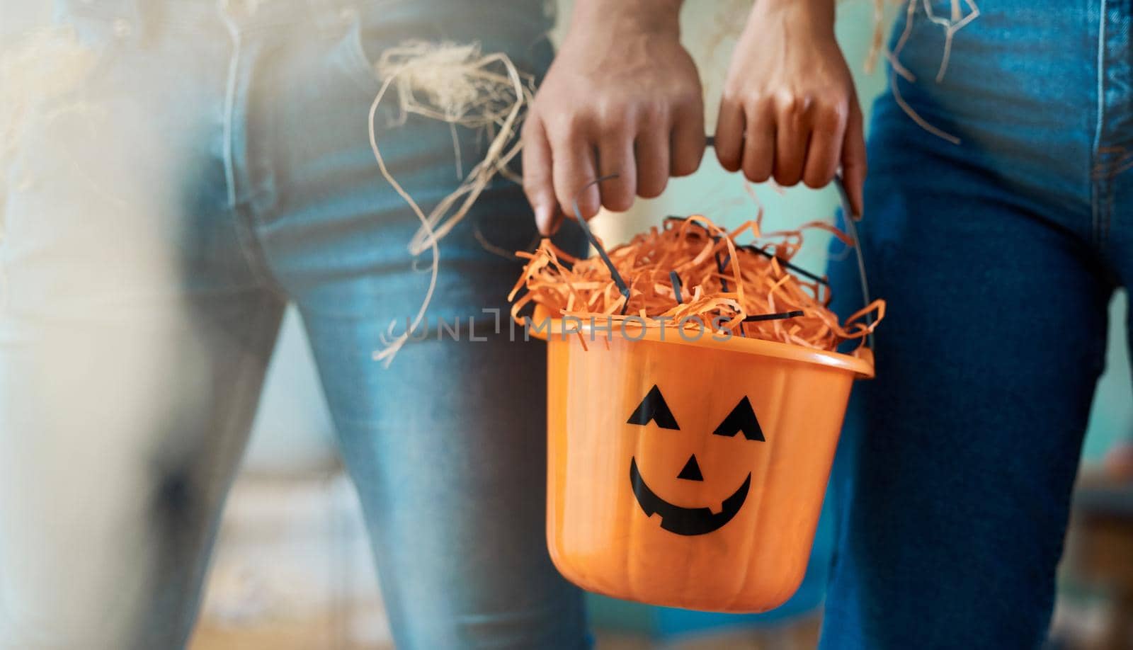 On the hunt for the best candy. two unrecognizable people holding a bucket at home