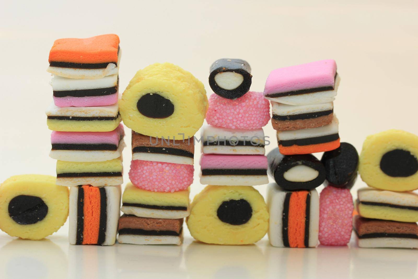 Stacked liquorice allsorts in different shapes, colors and sizes