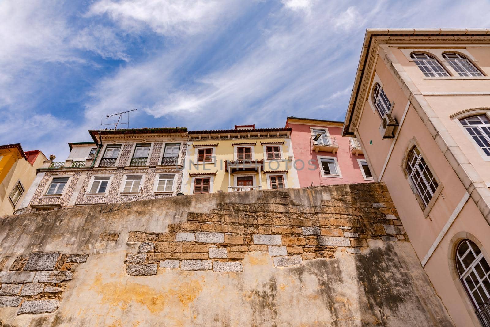 Looking up to the city walls and quaint houses of the historic city of Coimbra, Portugal
