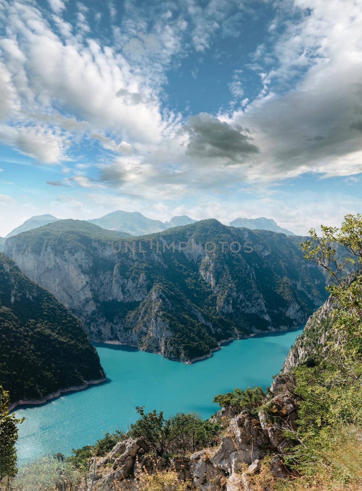 The concept of eco-tourism and active recreation. National Park. Mountain Emerald lake in the wooded mountains. Sunny day in autumn.