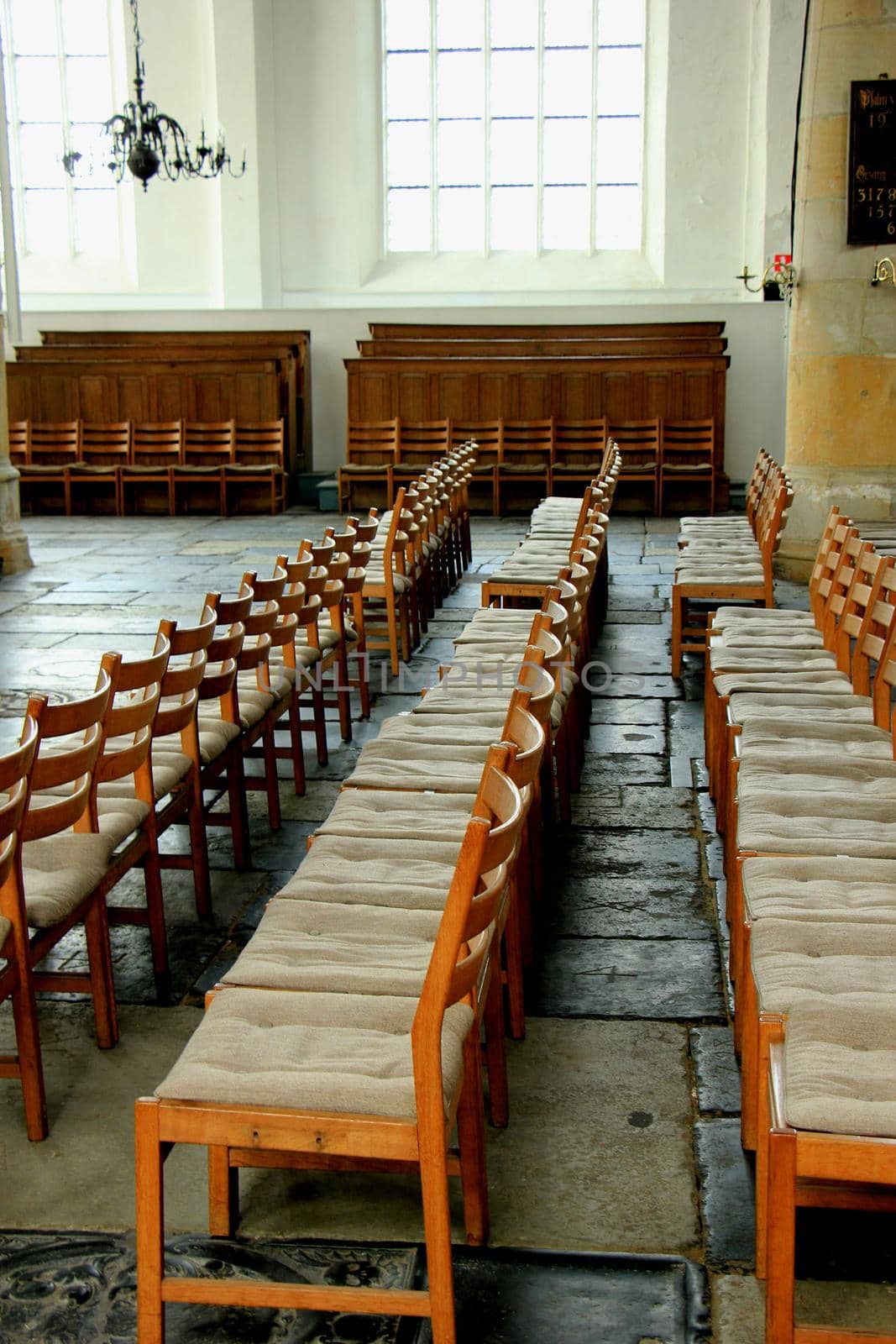 Simple wooden chairs in a Dutch Reformed Church by studioportosabbia