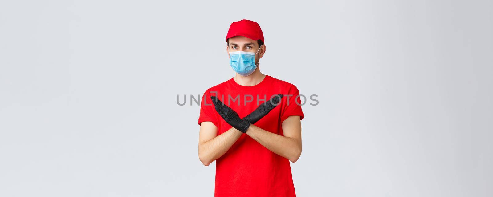 Covid-19, self-quarantine, online shopping and shipping concept. Courier disapprove contact during shipping goods, refuse or rejecting work without face mask and gloves, make cross sign.