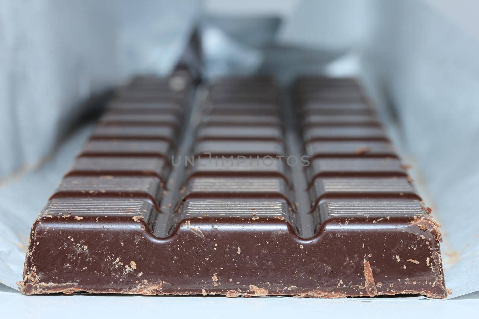 a dark chocolate bar , blocks in closeup