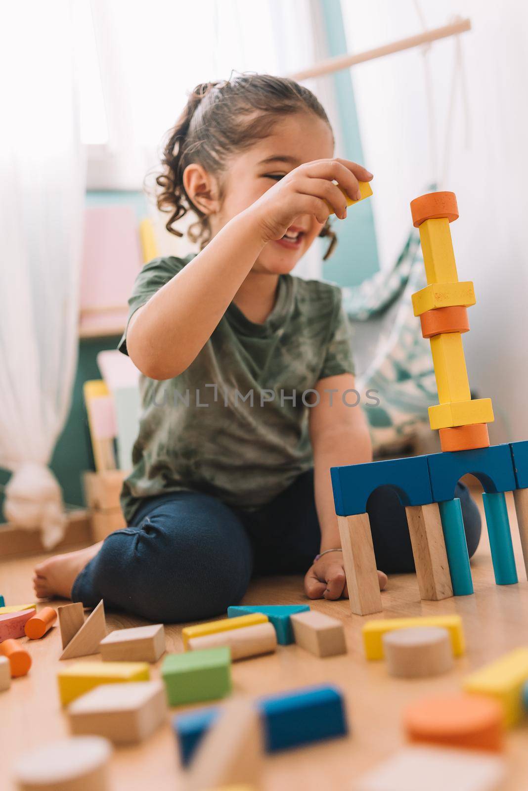 funny little girl playing happy in the floor with colorful wooden building block toys at home or kindergarten, educational toys for creative children