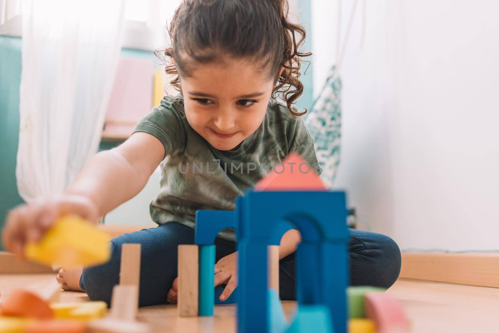 girl making constructions with building blocks by raulmelldo