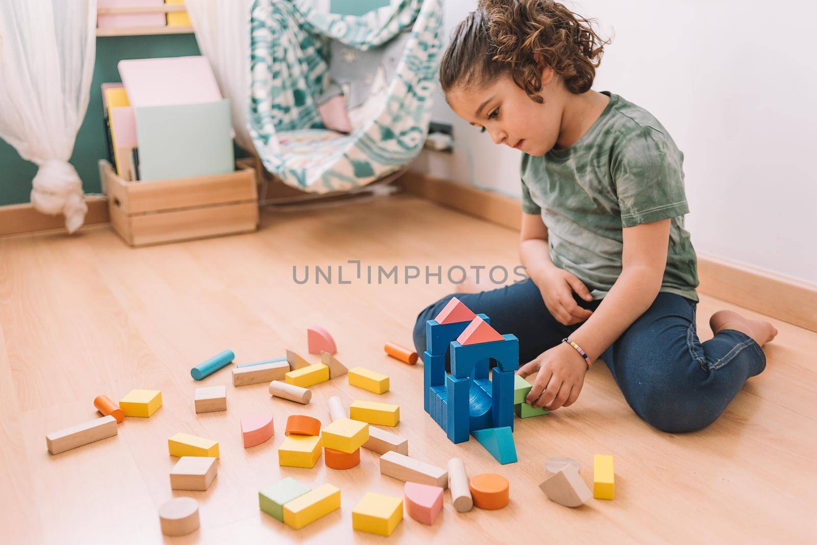 child little girl playing on the floor with wooden building block toys at home or kindergarten, educational toys for creative children