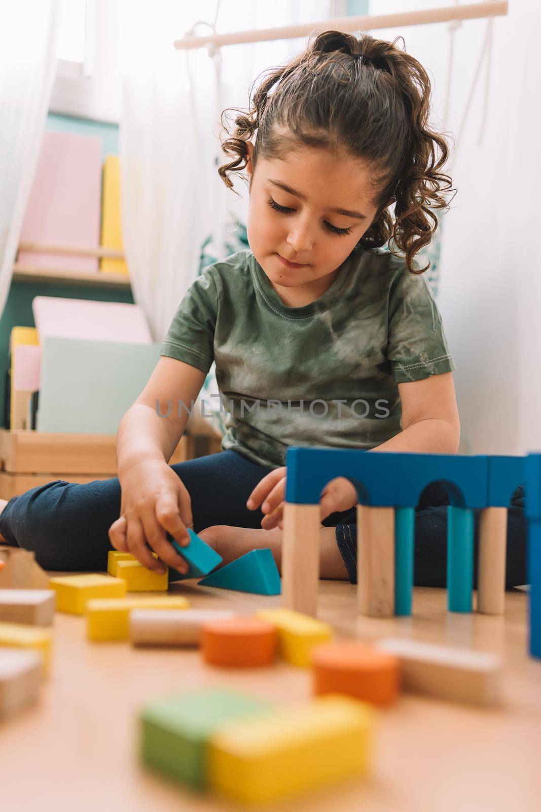 girl plays happy to build with building blocks by raulmelldo