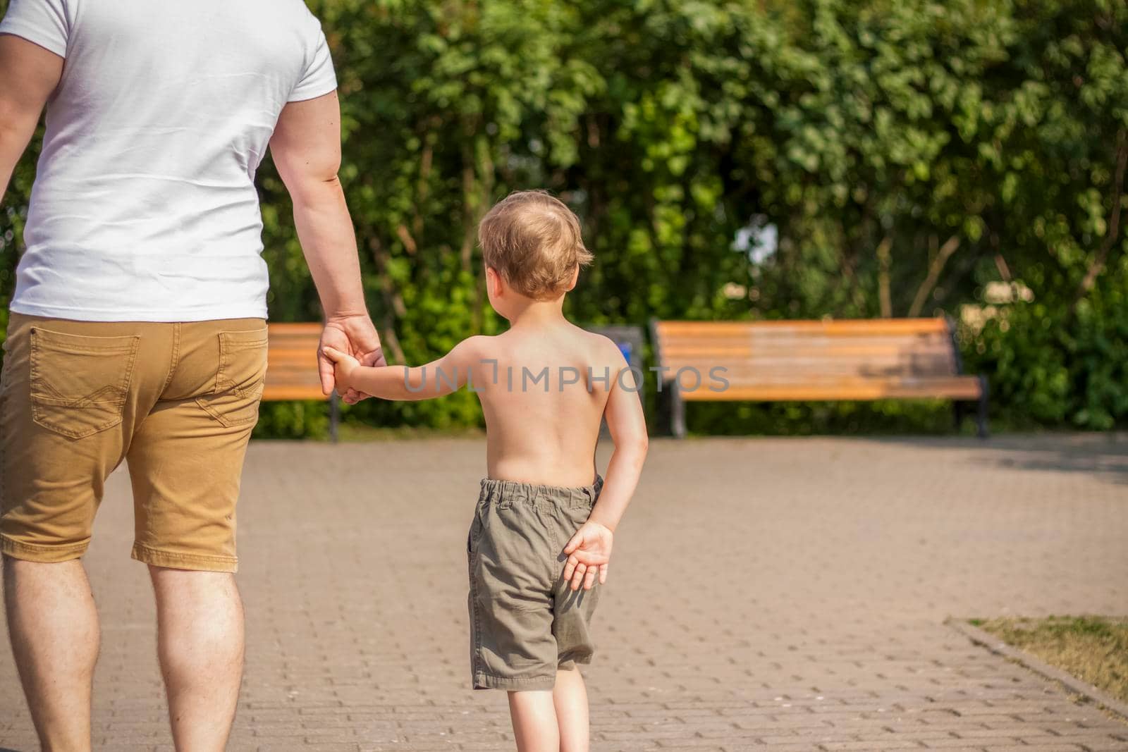 Walking in the park on a summer day by the river and experiencing the joy of walking. summer heat, a child without a T-shirt. Summer