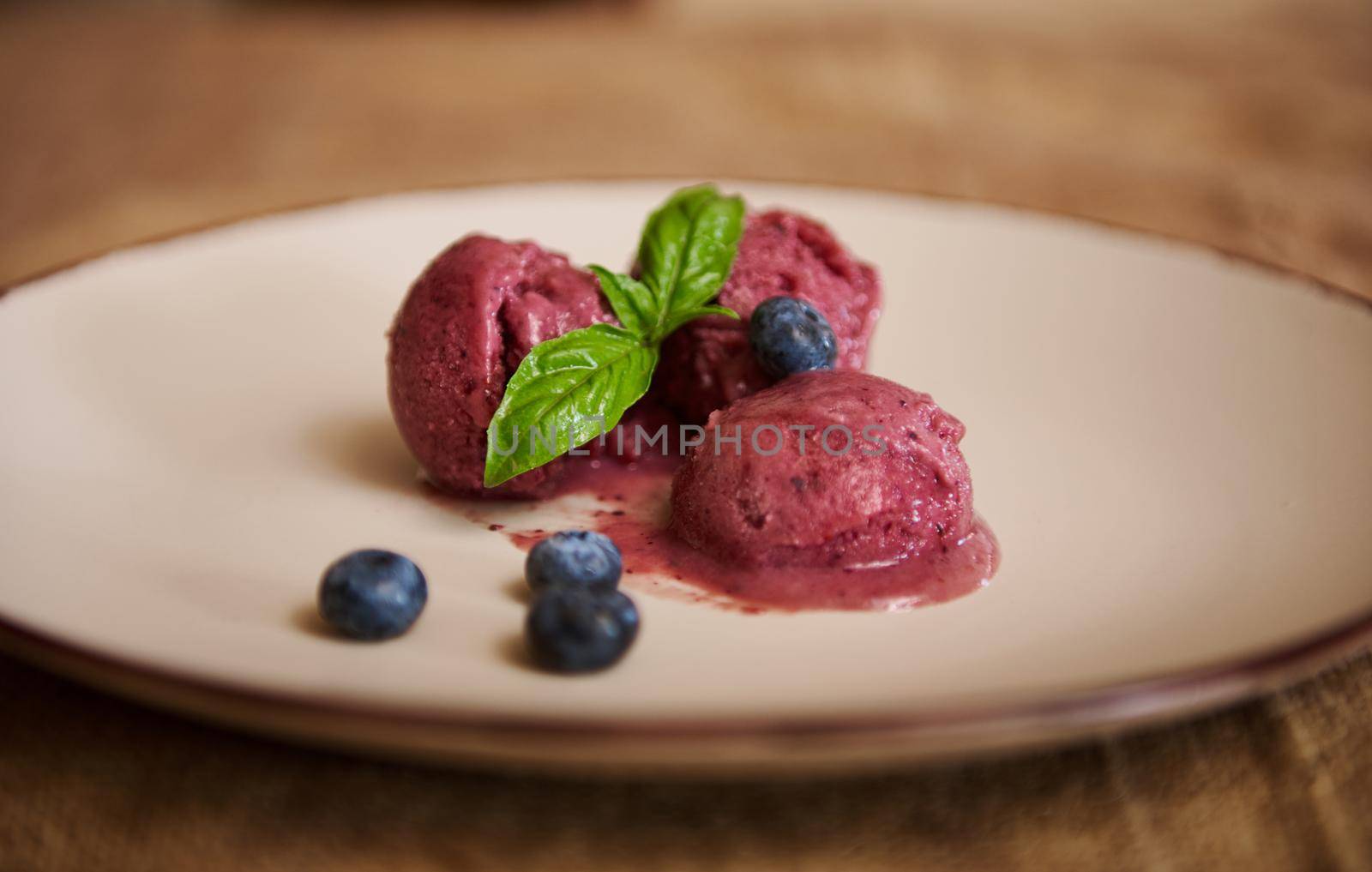 Blueberry sorbet purple ice-cream with lemon basil leaves. Raw vegan dairy free and gluten free dessert. Healthy Eating. Vegetarian food, natural dessert, home cooking. Still life. Food background