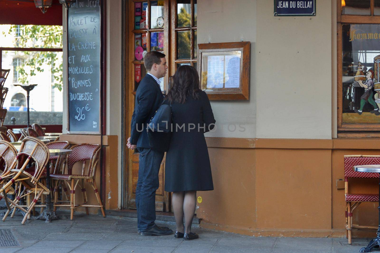 PARIS, FRANCE - OCTOBER 16, 2016: A couple of men and women studying the menu in the famous Parisian cafe ice cream Berthillon near Notre Dame de Paris