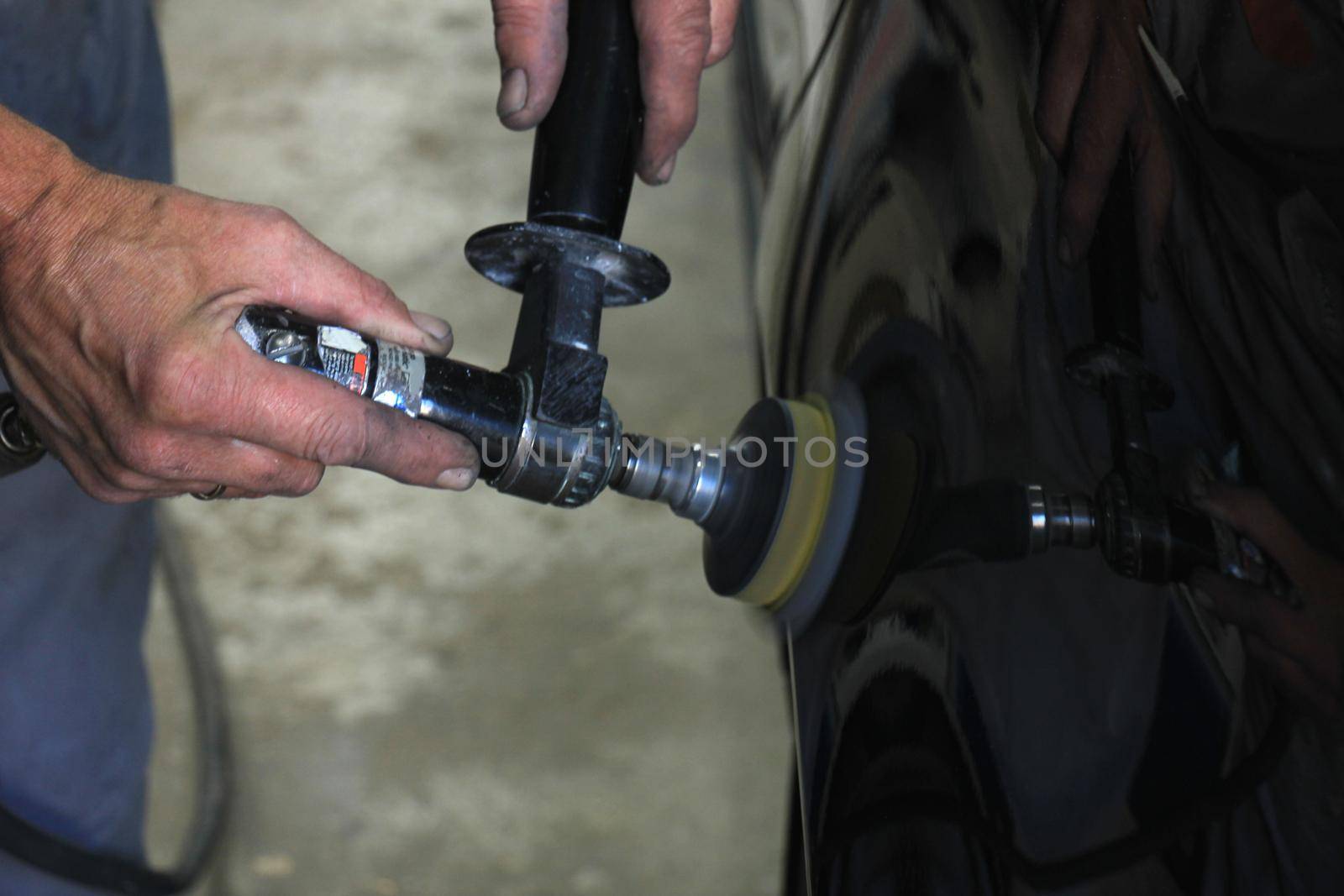 Man polishing a car after a car repair job