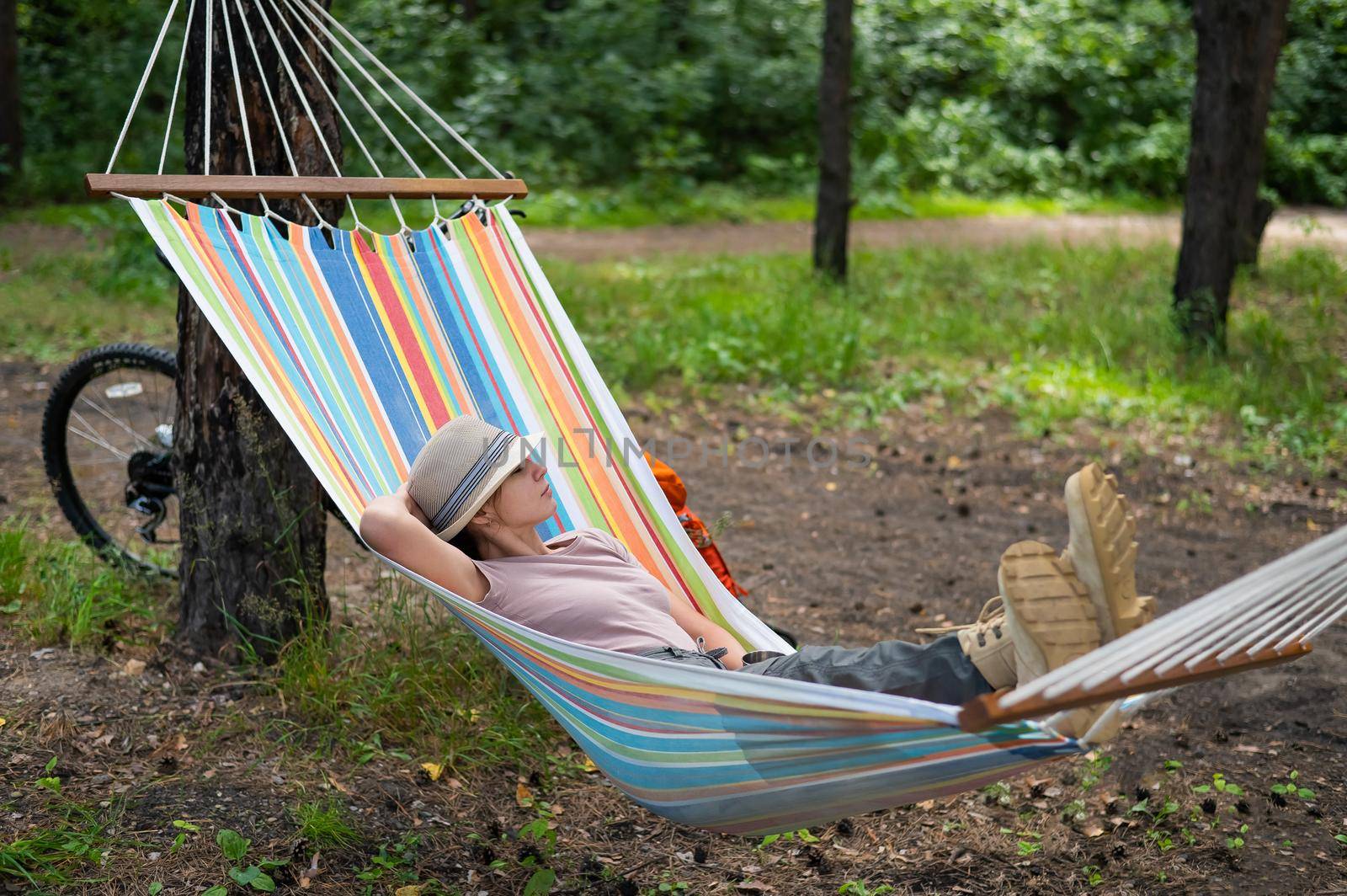 Caucasian woman lies in a hammock in a pine forest by mrwed54