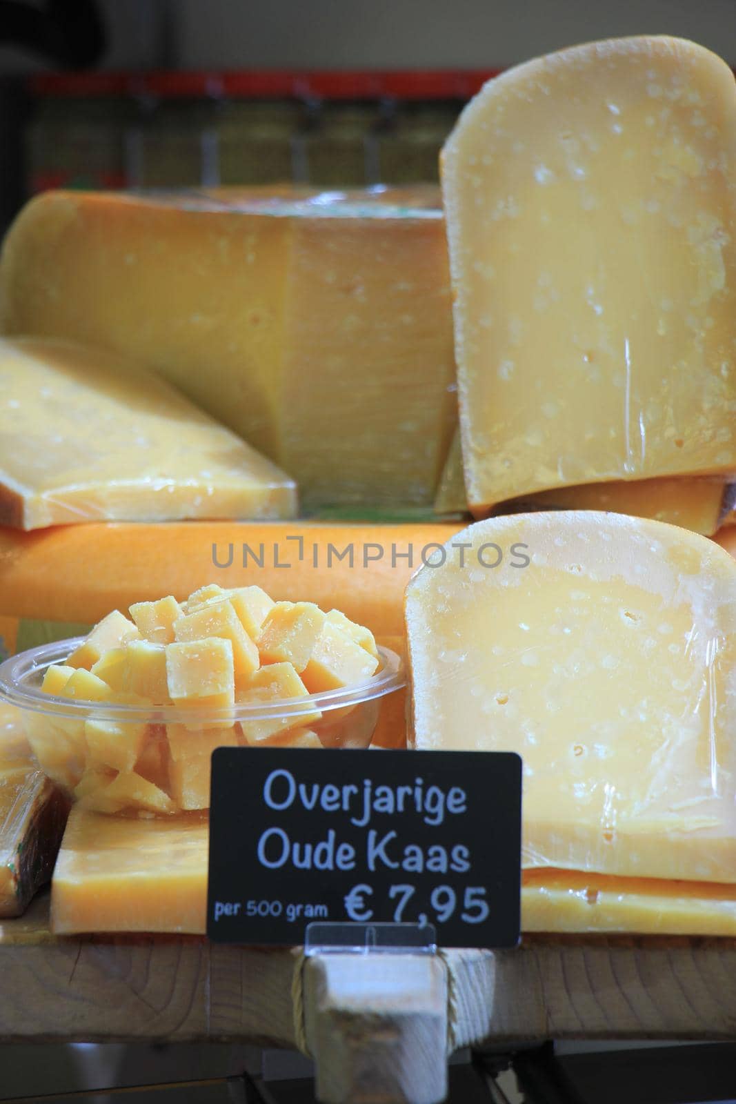 Traditional Dutch cheeses on display on a market stall, Text on tag: product information in Dutch: very matured old cheese