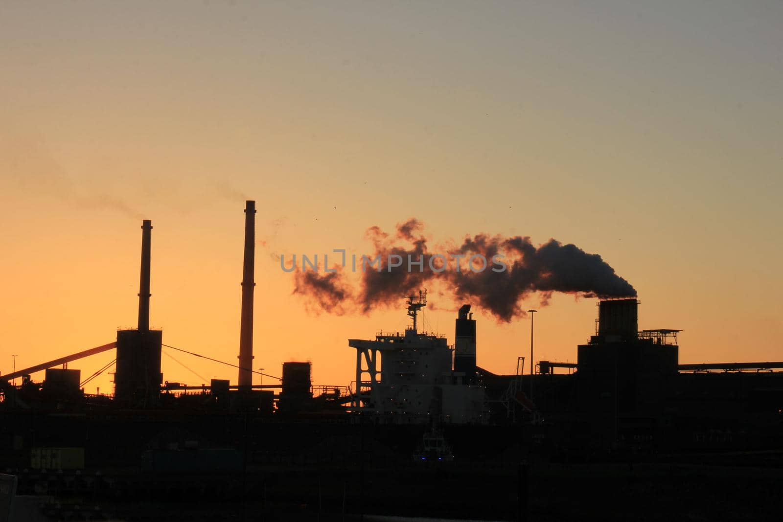 Skyline of an industrial area during sunset by studioportosabbia