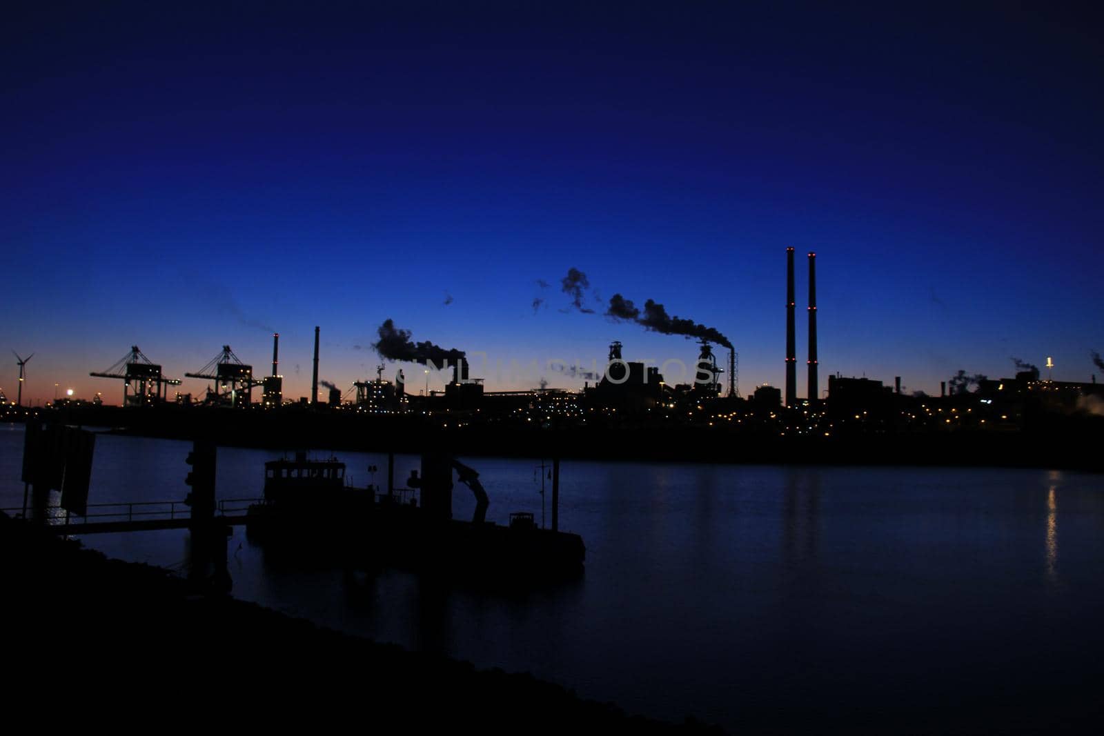 Skyline of an industrial area during sunset by studioportosabbia