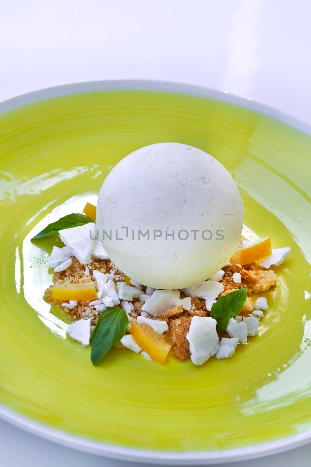 Vanilla ice cream, lemon and basil on a plate