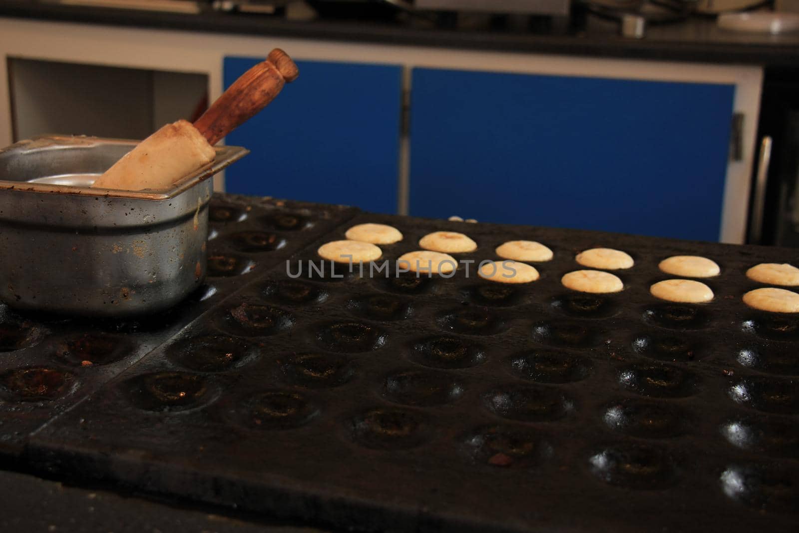 Poffertjes, Dutch small, fluffy pancakes, made on hot cast iron plate, served with powdered sugar and butter.