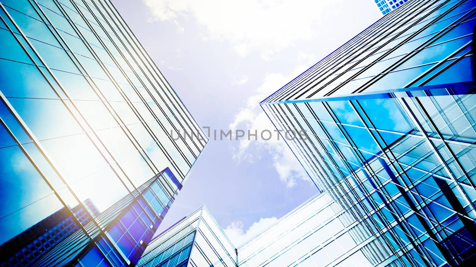 Glass buildings business concept. The glass facade of a skyscraper with a mirror reflection of sky windows. Modern office building with glass facade on a clear sky background. 3d Rendering by Dvorak