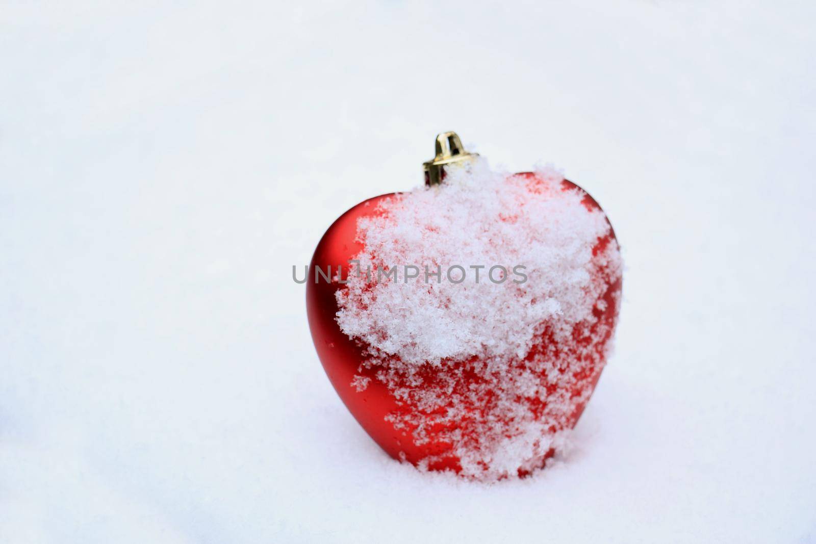 Red heart shaped ornament in fresh fallen snow