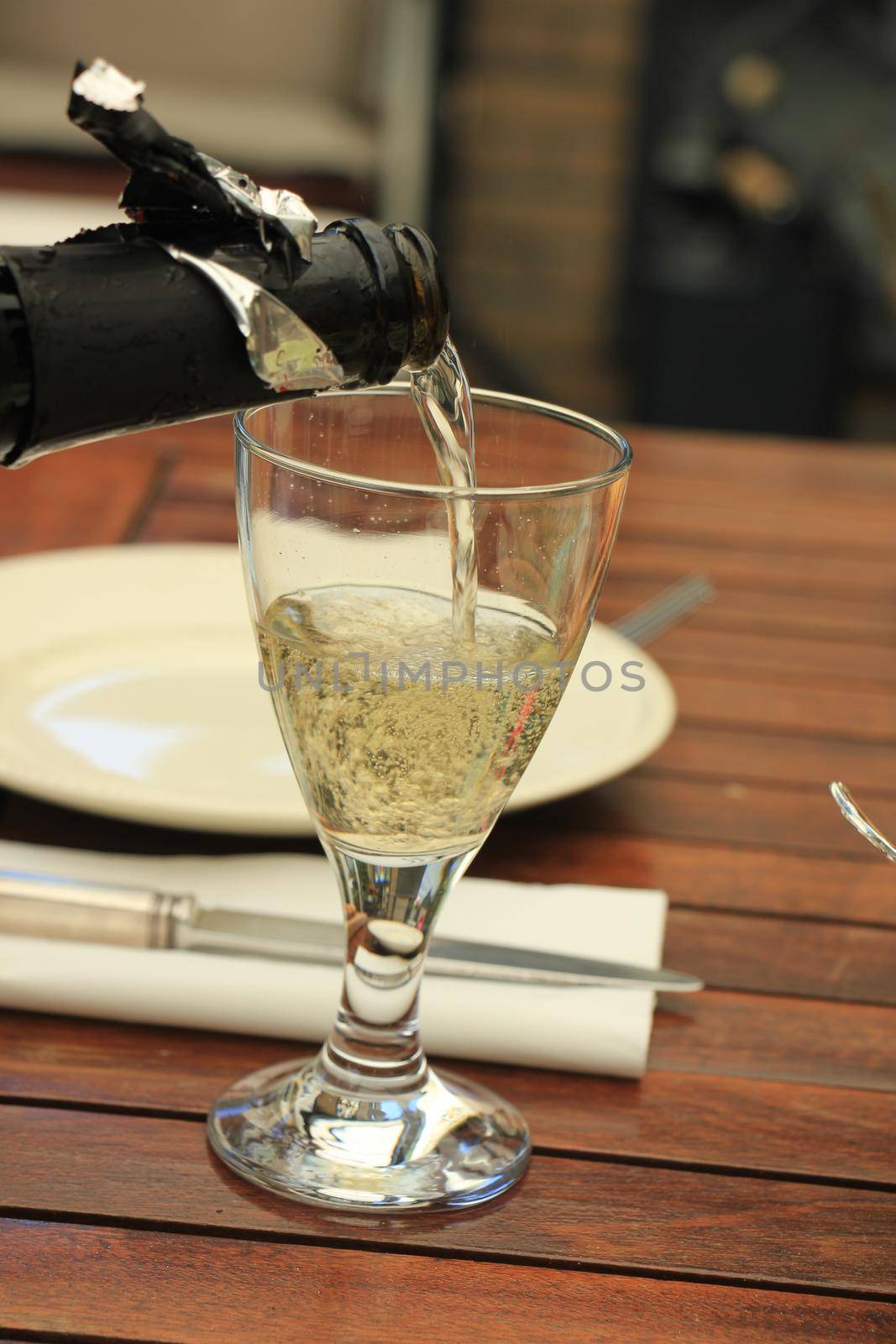 Man pouring white wine at a dinner table