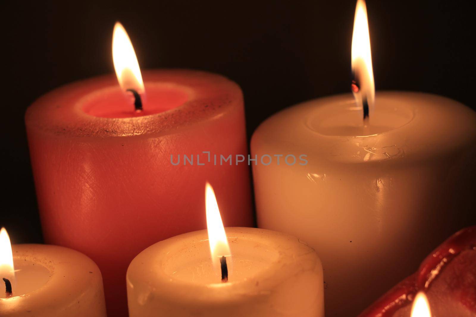 Group of burning candles in different heights and colors