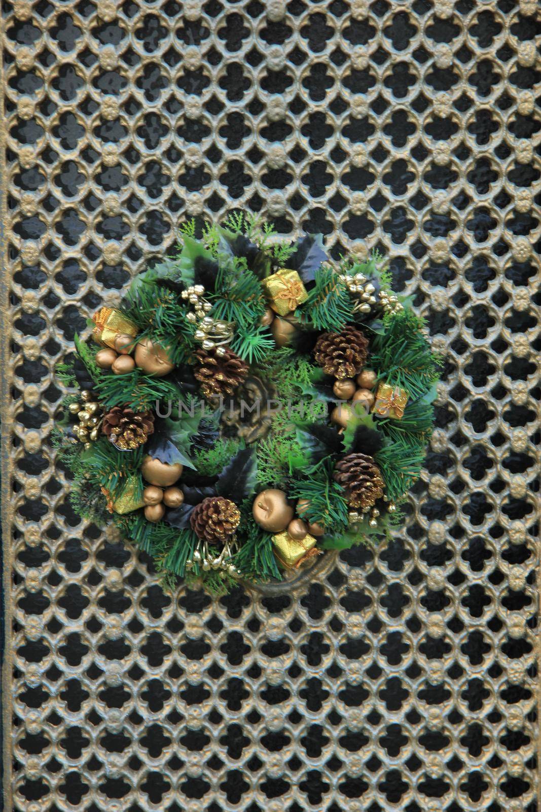 Classic christmas wreath with decorations on a door by studioportosabbia