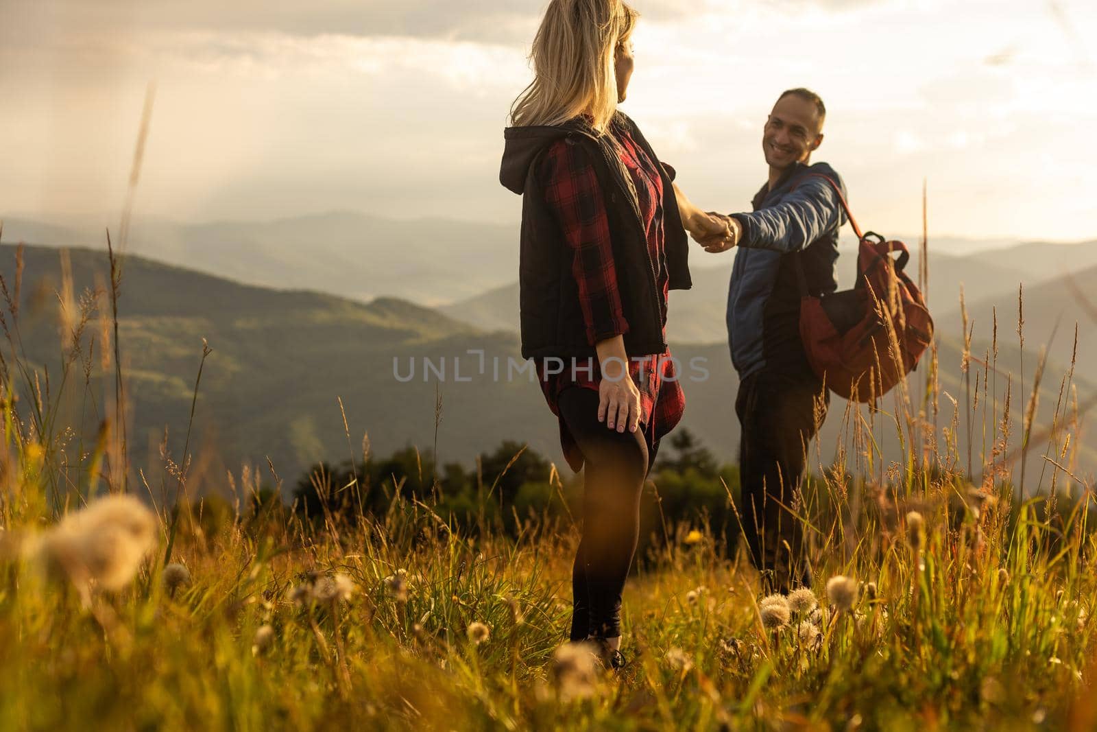 beautiful young couple enjoying nature at mountain by Andelov13