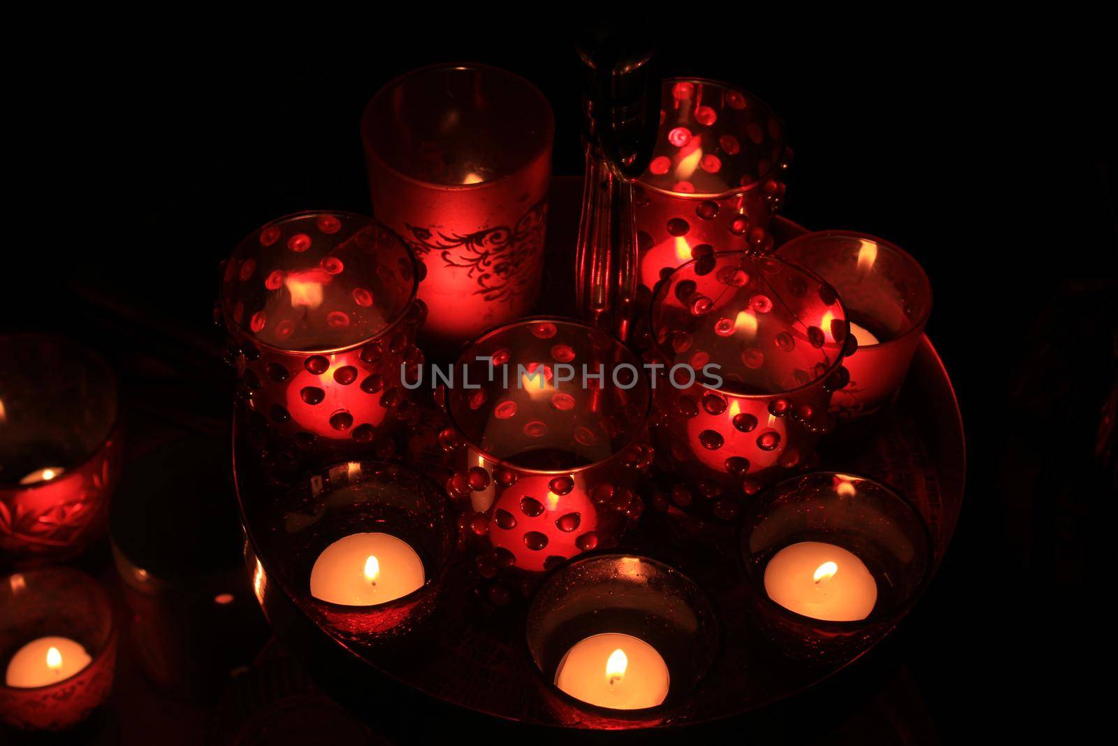 Red candles and votive lights burning in a christmas arrangement