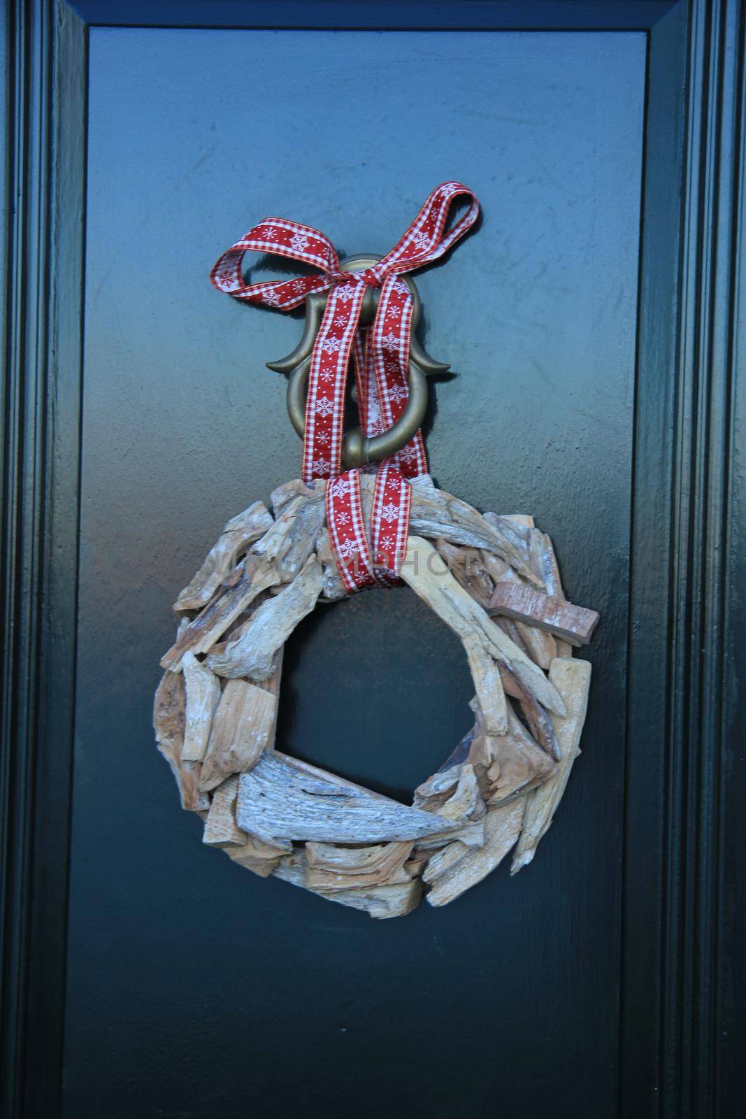 Classic christmas wreath with decorations on a door by studioportosabbia