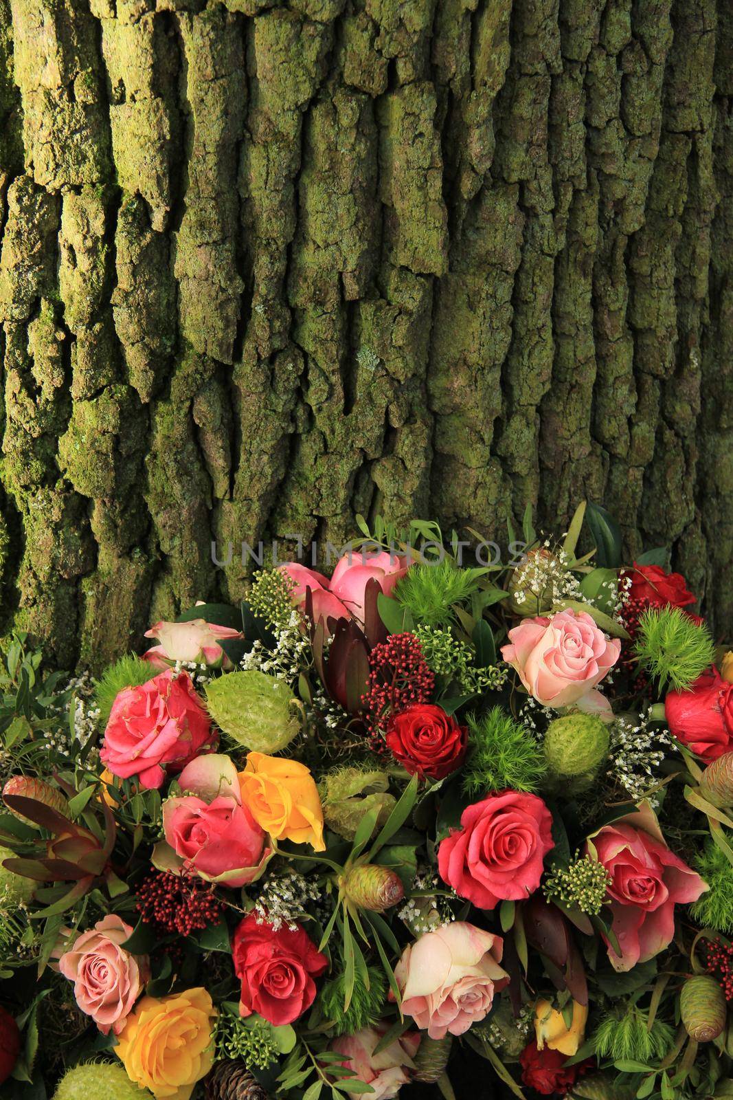 A floral sympathy wreath near a tree