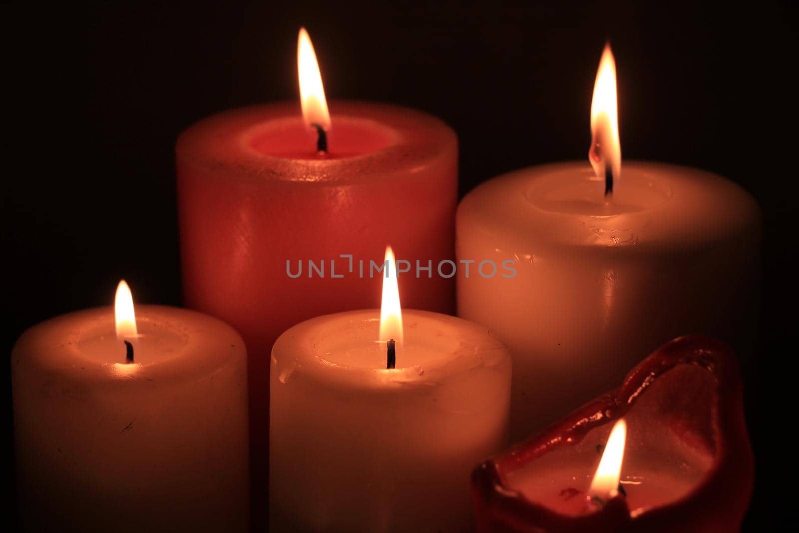 Group of burning candles in different heights and colors